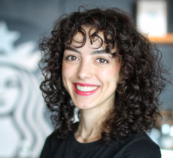 A woman sitting on a stool next to a podium